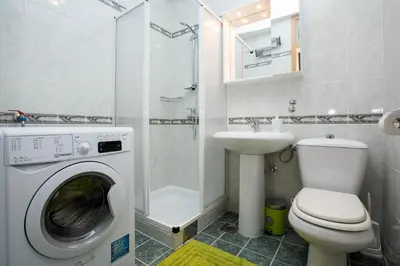 a bathroom with a washing machine and a sink at Podkoren Apartments in Kranjska Gora
