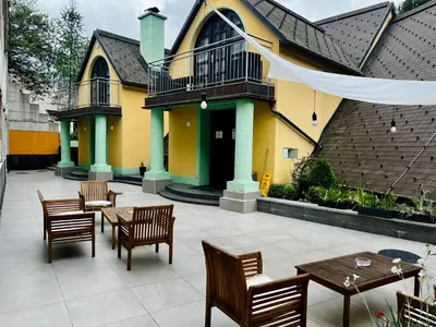 a patio with tables and chairs and a building at Podkoren Apartments in Kranjska Gora