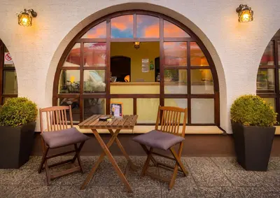 a table and two chairs in front of a building at 1A Adventure Hostel in Lesce