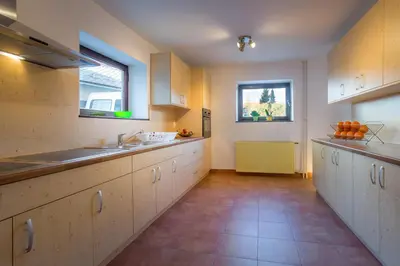 a large kitchen with white cabinets and a sink at 1A Adventure Hostel in Lesce