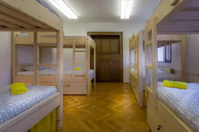 a room with four bunk beds and wooden floors at 1A Adventure Hostel in Lesce