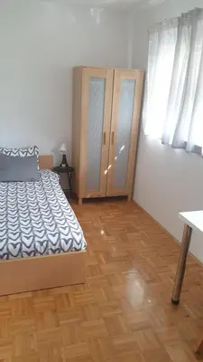 a bedroom with a bed and a wooden floor at Apartment EMMA Ljubljana - FREE parking, AC, Wifi in Ljubljana