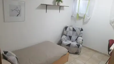 a bedroom with a bed and a chair in a room at Apartment EMMA Ljubljana - FREE parking, AC, Wifi in Ljubljana