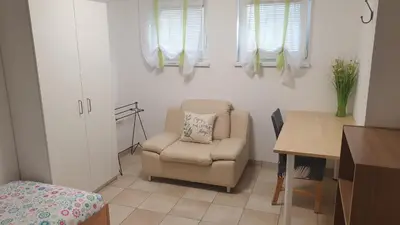 a living room with a chair and a table at Apartment EMMA Ljubljana - FREE parking, AC, Wifi in Ljubljana