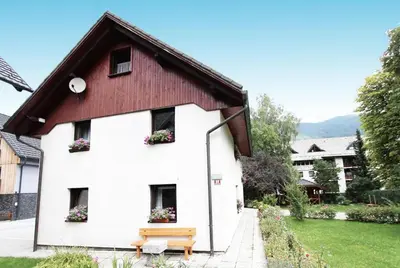 a white building with a bench in front of it at Apartment Bernik II in Kranjska Gora