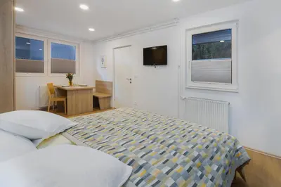 a bedroom with a bed and a desk and a table at Apartment Bernik II in Kranjska Gora