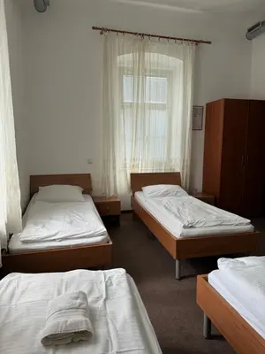 a room with three beds and a window at Guesthouse Pri Tonetu in Ptuj
