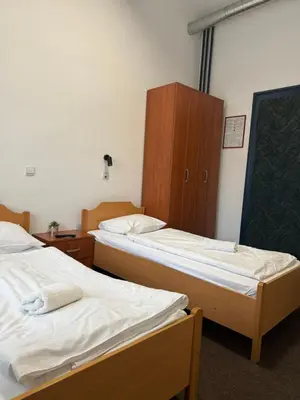 a room with two beds and a cabinet at Guesthouse Pri Tonetu in Ptuj