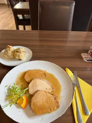 two plates of food on a wooden table at Guesthouse Pri Tonetu in Ptuj
