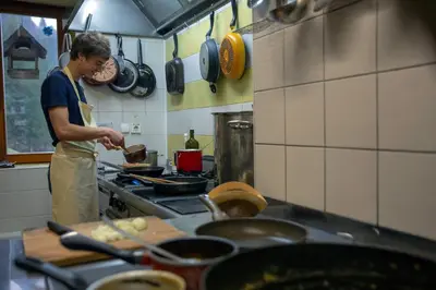 a man standing in a kitchen preparing food at Govc-Vršnik in Solčava