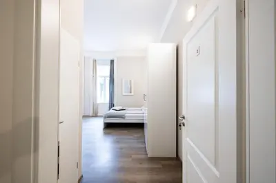 a hallway with white doors and a bed in a room at 4flats in Maribor