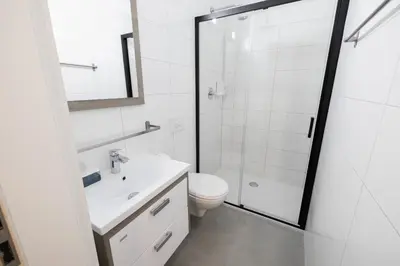 a white bathroom with a toilet and a shower at 4flats in Maribor