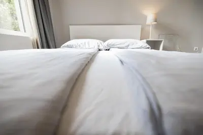 a white bed with two pillows on top of it at 4flats in Maribor