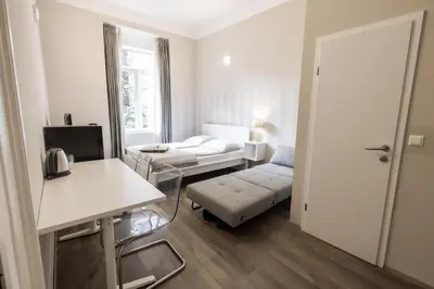 a white room with a bed and a couch at 4flats in Maribor