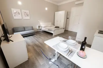 a white living room with a table and a couch at 4flats in Maribor