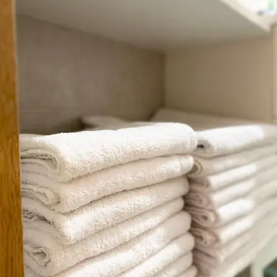 a stack of towels sitting on a shelf in a bathroom at Apartments Alpha Center in Bovec