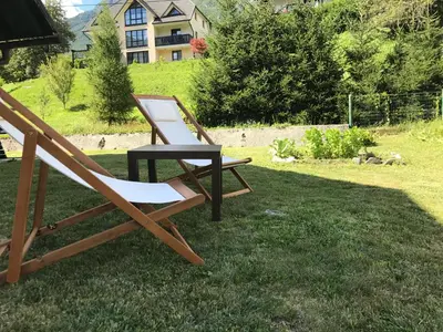 two chairs and a table on the grass at Apartments Alpha Center in Bovec