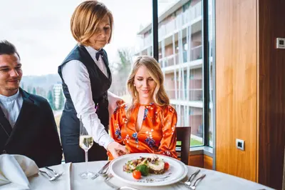 a woman sitting at a table with a plate of food at Atlantida Boutique Hotel in Rogaška Slatina