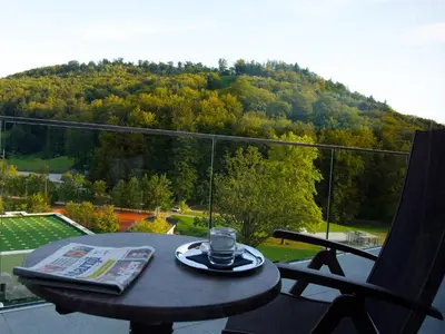 a table with a glass on it on a balcony at Atlantida Boutique Hotel in Rogaška Slatina
