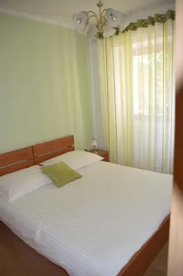 a bedroom with a large white bed with a window at Apartments Klabjan in Osp