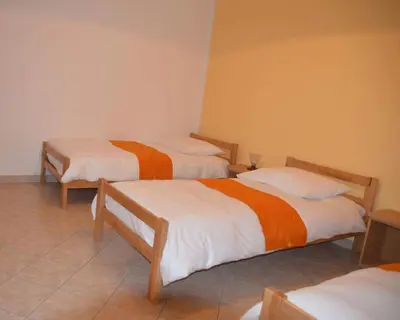 a room with two beds with white and orange sheets at Apartments Klabjan in Osp