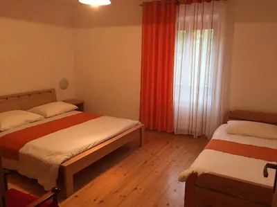 a bedroom with two beds and a window at Apartments Klabjan in Osp