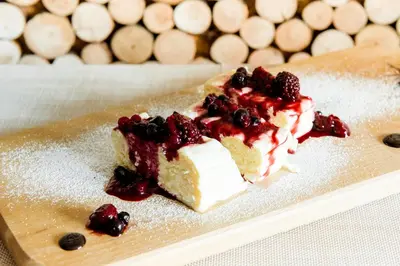 a piece of cake with berries on a plate at Hotel House Rozka in Cerklje na Gorenjskem