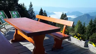 a wooden bench sitting on top of a mountain at Apartmaji Srnca in Cerkno