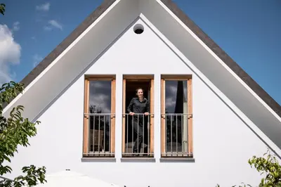a man standing in a window of a house at Škrabčeva domačija in Ribnica