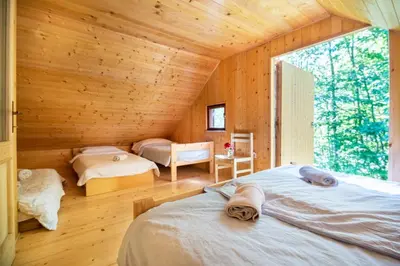 a bedroom with two beds in a wooden cabin at Miha lodge - Mihčevo pleče in Soča