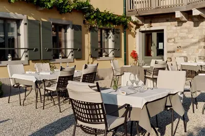 a group of tables and chairs in front of a building at Casa Krasna Gourmet Boutique Hotel in Lokev