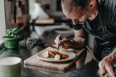 a man eating a sandwich on a plate on a counter at Casa Krasna Gourmet Boutique Hotel in Lokev