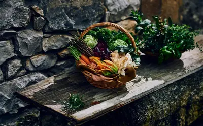 a basket of vegetables sitting on a table at Casa Krasna Gourmet Boutique Hotel in Lokev
