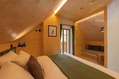 a bedroom with a bed and a couch in a room at PRIVILLAGE Stare - Villa & Chalet in Bohinj