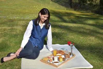 a woman sitting on a table with a tray of food at PRIVILLAGE Stare - Villa & Chalet in Bohinj