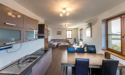 a kitchen and living room with a table and chairs at Apartmaji Smogavc in Zreče