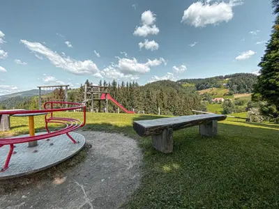 a park with a bench and a playground at Apartmaji Smogavc in Zreče