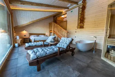 a room with two beds and a tub and a bedroom at Apartmaji Smogavc in Zreče