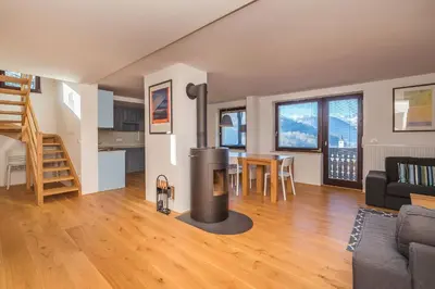 a living room with a wood stove in the middle at Villa Bohinca in Bohinj