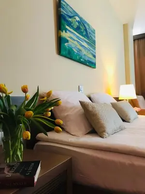 a bed with white pillows and a painting on the wall at Hotel Kras in Postojna