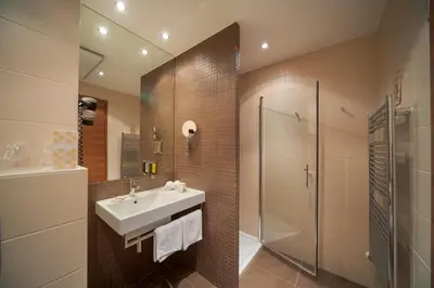 a bathroom with a sink and a shower at Hotel Kras in Postojna