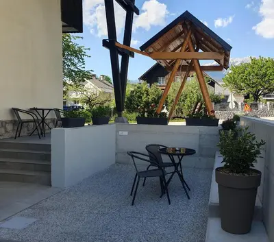a patio with chairs and a table and some plants at Pension TTT in Bled