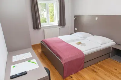 a bedroom with a bed and a table with a remote control at Hotel Pokljuka in Goreljek