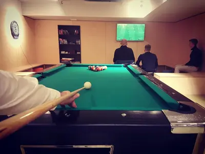 a group of men playing pool in a room at Hotel Pokljuka in Goreljek