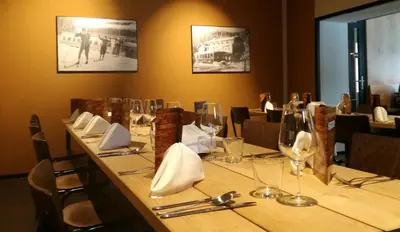 a long table in a restaurant with wine glasses at Hotel Pokljuka in Goreljek