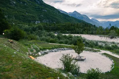 a park with a picnic table in the middle of a river at Hotel Boka in Bovec