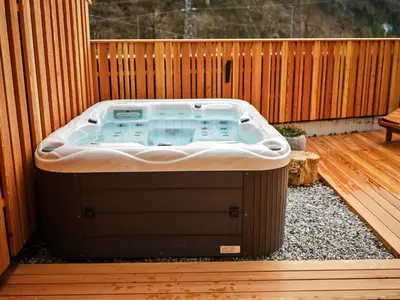 a hot tub sitting on a deck with a fence at Hotel Boka in Bovec