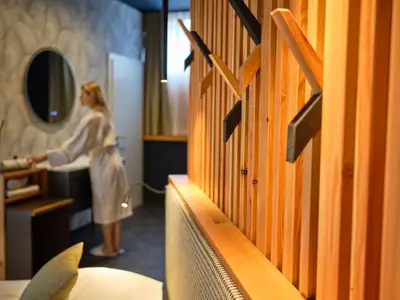 a woman standing in a hotel room with a hose at Hotel Boka in Bovec