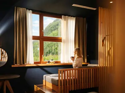 a little girl sitting on a crib looking out a window at Hotel Boka in Bovec