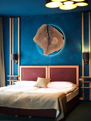a bedroom with a bed with a blue wall at Hotel Boka in Bovec